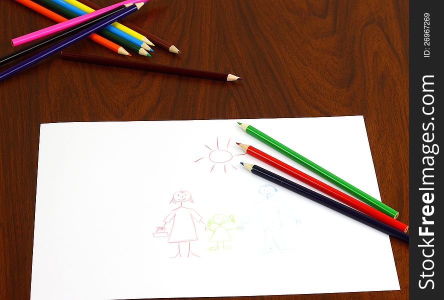 Three color pencils lie on table over the drawing. Bunch of other pencils lies behind