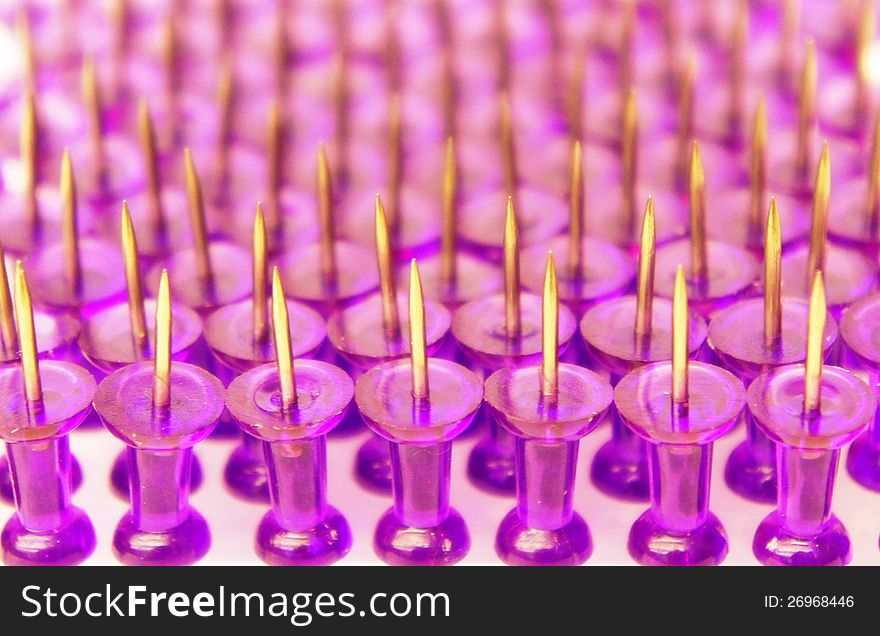 Purple pins close-up on white background standing points up. Purple pins close-up on white background standing points up