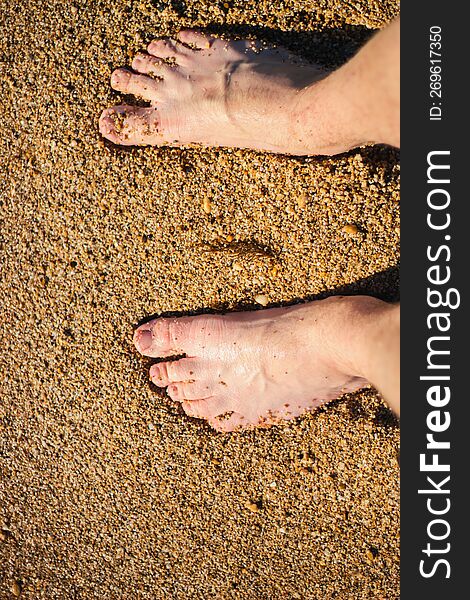 Men S Feet Are Standing On A Sandy Beach. Crystal Water On The Seashore.