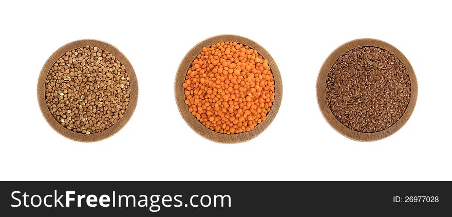 Buckwheat, red lentils and flax seeds on wooden plate isolated on white background. Buckwheat, red lentils and flax seeds on wooden plate isolated on white background