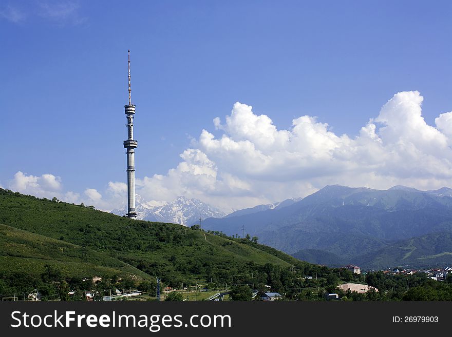 Television tower against mountains and blue sky