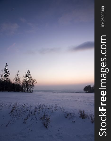 Snowy landscape after sunset with the moon in the sky. Snowy landscape after sunset with the moon in the sky