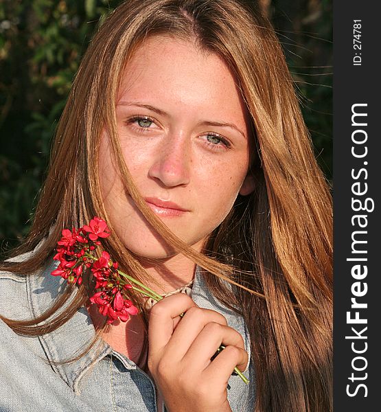 A beautiful, glamorous teen girl holding a flower. A beautiful, glamorous teen girl holding a flower.