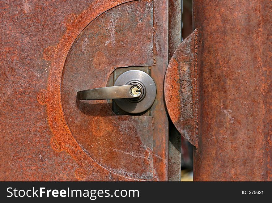 Heavily rusting door or gate closeup with lock