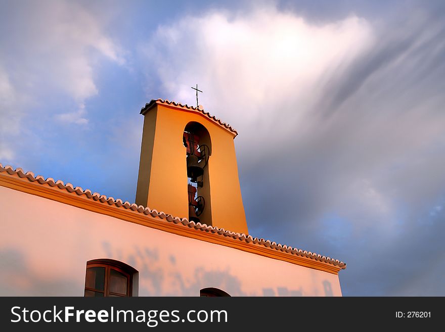 Old spanish church sunset with beautiful strange clouds. This is the church of Santa Gertrudis, Ibiza, Spain (anno 1830). With the shadows of a Almond tree. Santa gERTRUDIS.
