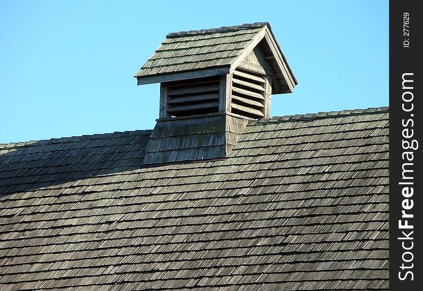 A wooden roof with blue sky as background.