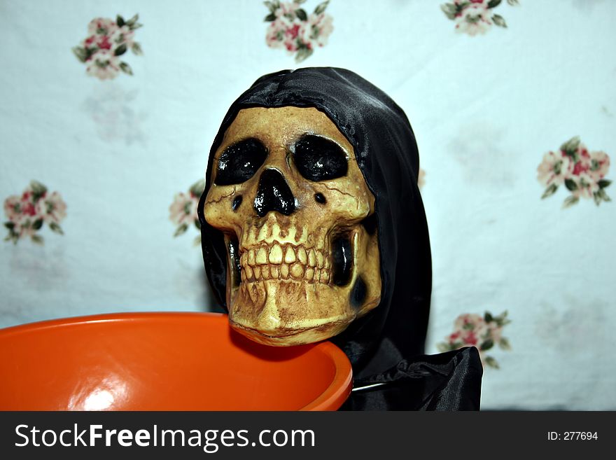Skeleton holding a candy dish against a white background. Skeleton holding a candy dish against a white background