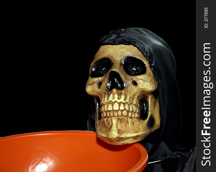 A skeleton holding an empty candy bowl. A skeleton holding an empty candy bowl