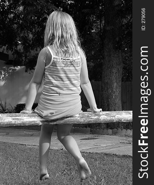 Black and white image of a young girl on a split rail fence. Black and white image of a young girl on a split rail fence.