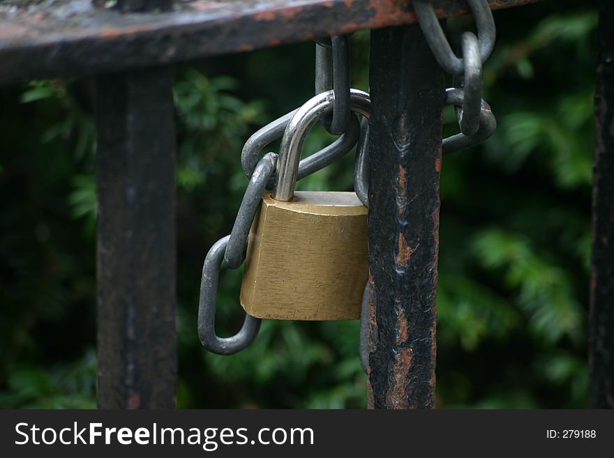 Steel and Brass Padlock and Steel Chain on Old Black Iron Gate. Steel and Brass Padlock and Steel Chain on Old Black Iron Gate