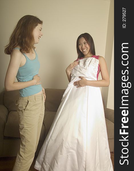 Girl shows her friend her wedding dress