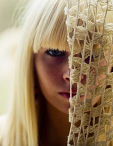 Blond Woman S Face Behind Net Stock Image