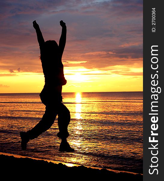 Woman jumping on the beach at sunrise. Woman jumping on the beach at sunrise