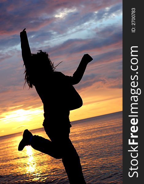 Woman jumping on the beach at sunrise. Woman jumping on the beach at sunrise