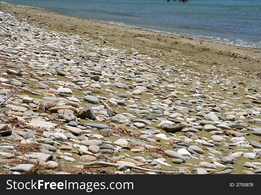 A part of a beach with sand and pebbles. A part of a beach with sand and pebbles