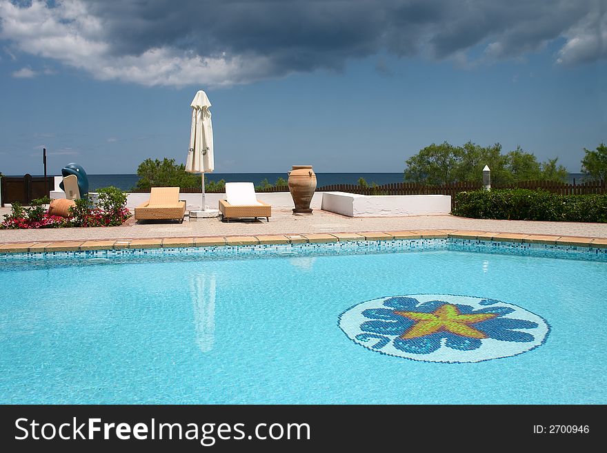 Swimming pool with sunshade on the seaside