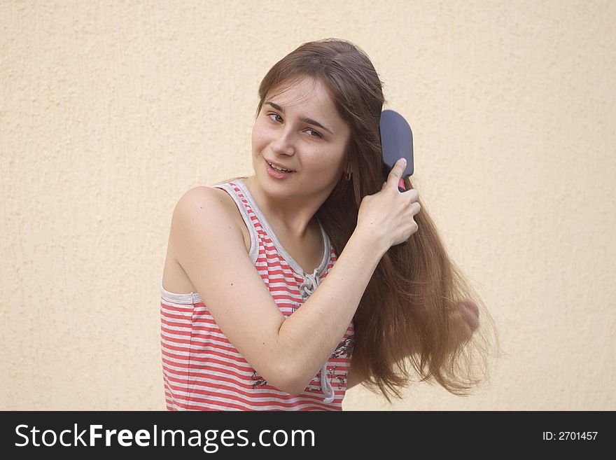 Young woman brushing her long hair. Young woman brushing her long hair