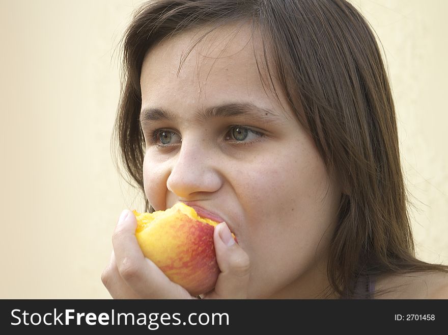 Young girl eating big juicy peach. Young girl eating big juicy peach