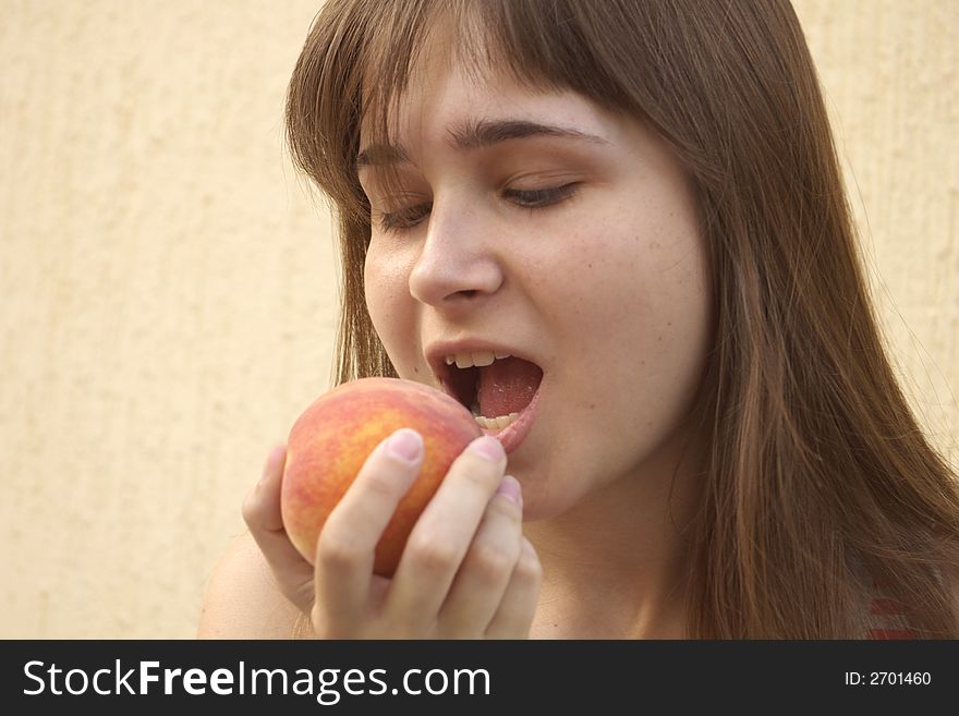 Young girl eating big juicy peach. Young girl eating big juicy peach