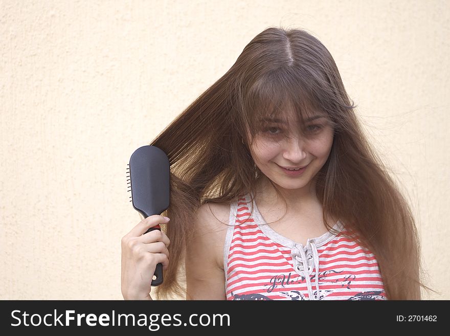 Young woman brushing her long hair. Young woman brushing her long hair