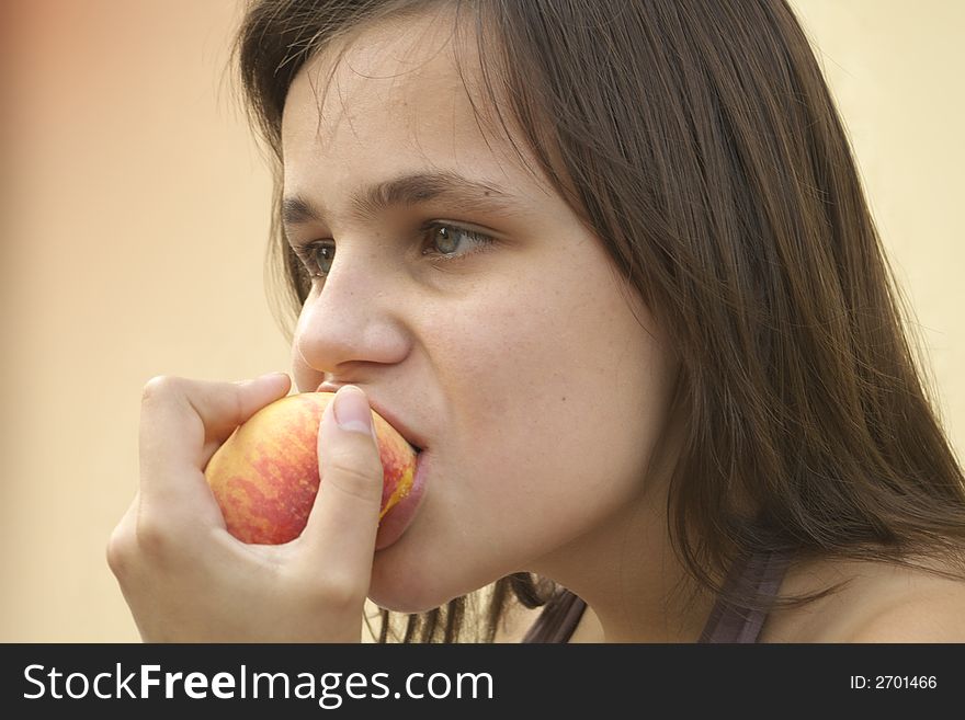 Girl eating big peach
