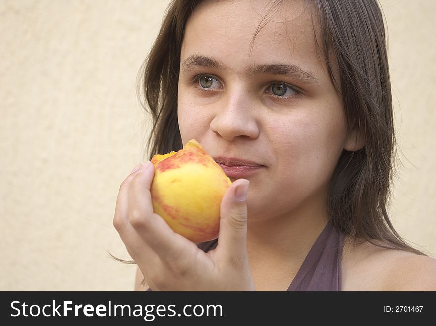 Young girl eating big juicy peach. Young girl eating big juicy peach