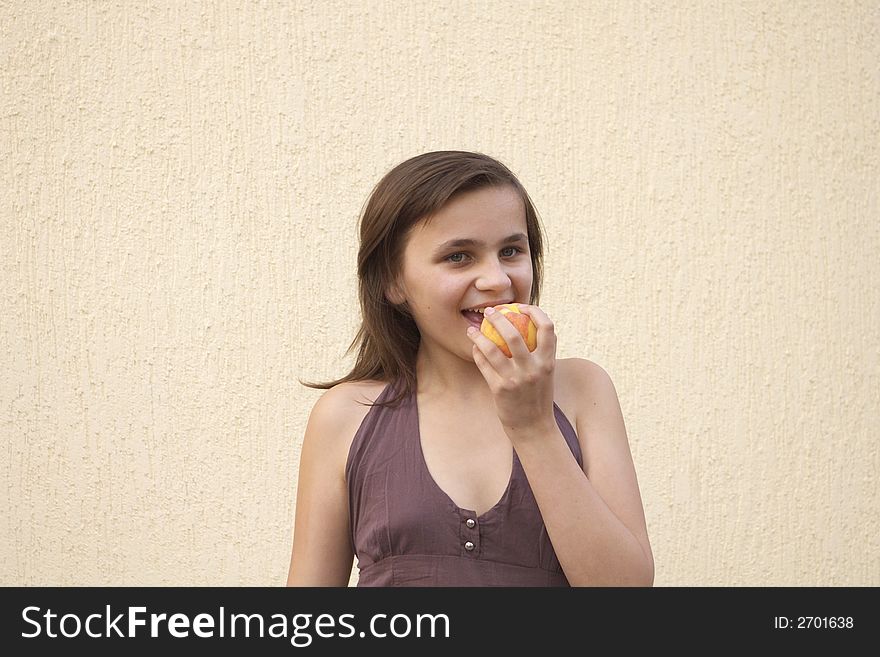 Young girl eating big juicy peach. Young girl eating big juicy peach