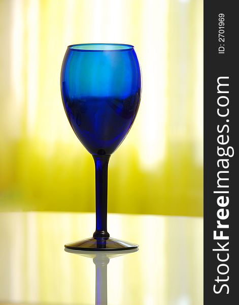 Blue cobalt vine glass on yellow background