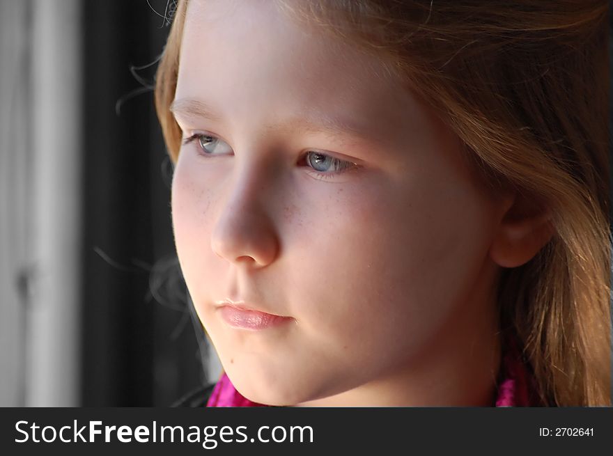 Young girl daydreaming out of window. Young girl daydreaming out of window