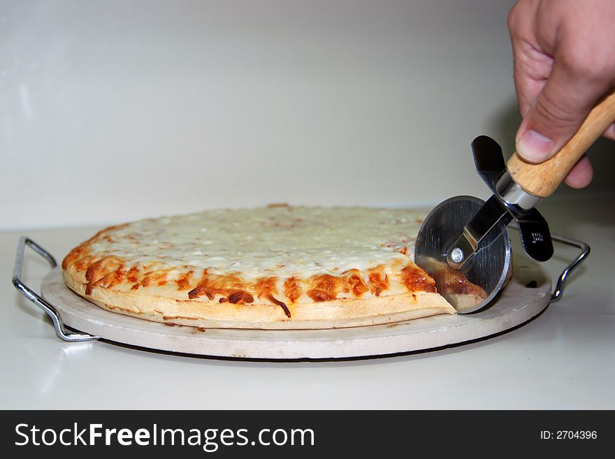 Chef cutting into a pizza. Chef cutting into a pizza