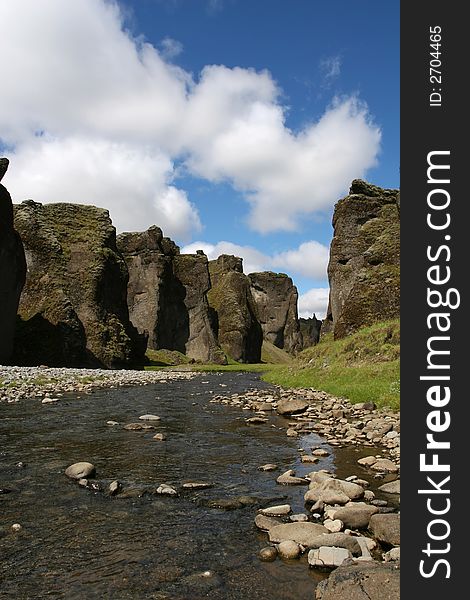 Magnificent scenic from inside a river canyon in southern Iceland, cliffs on all sides, and blue sky above. Magnificent scenic from inside a river canyon in southern Iceland, cliffs on all sides, and blue sky above
