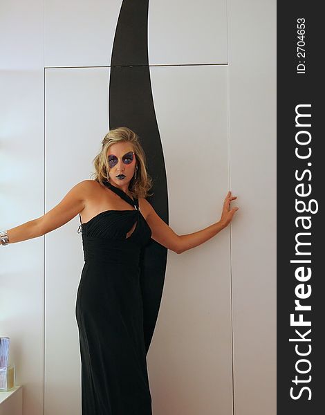 A makeup model posing against a black and white wall. A makeup model posing against a black and white wall