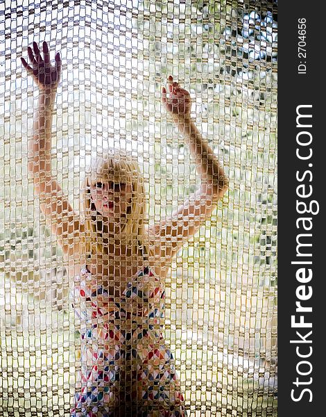 Young blonde girl behind a net