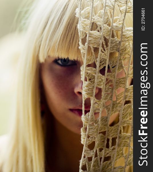 Blond woman s face behind net