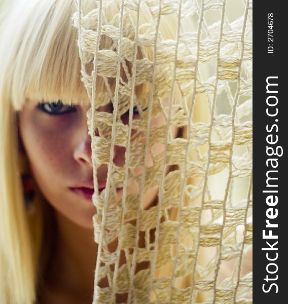 Blond woman s face behind net