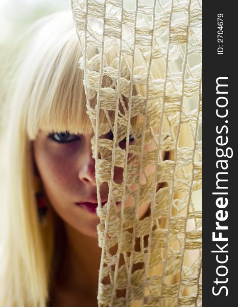 Blond woman s face behind net