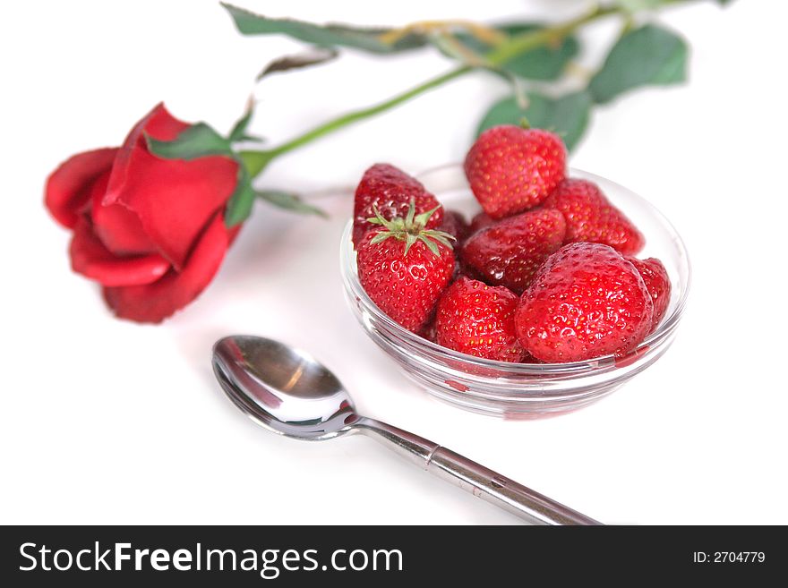 A bowl of fresh strawberries and a single red rose. A bowl of fresh strawberries and a single red rose.
