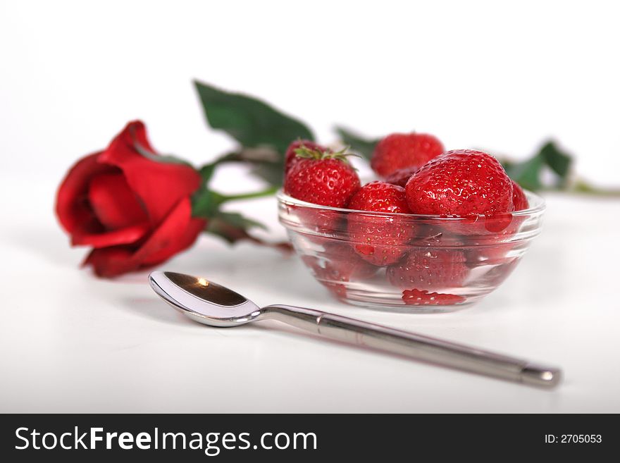 A fresh bowl of strawberries and a single red rose. A fresh bowl of strawberries and a single red rose.