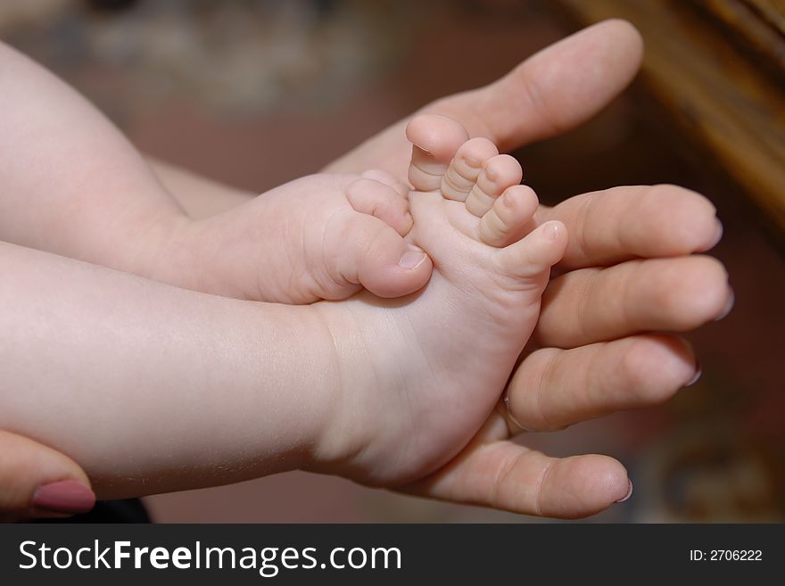 Foot of baby in hands of adult man. Foot of baby in hands of adult man