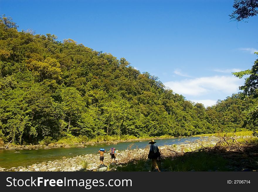 Hikers crossing one of the rivers in Palanan, Isabela, Philippines. Hikers crossing one of the rivers in Palanan, Isabela, Philippines