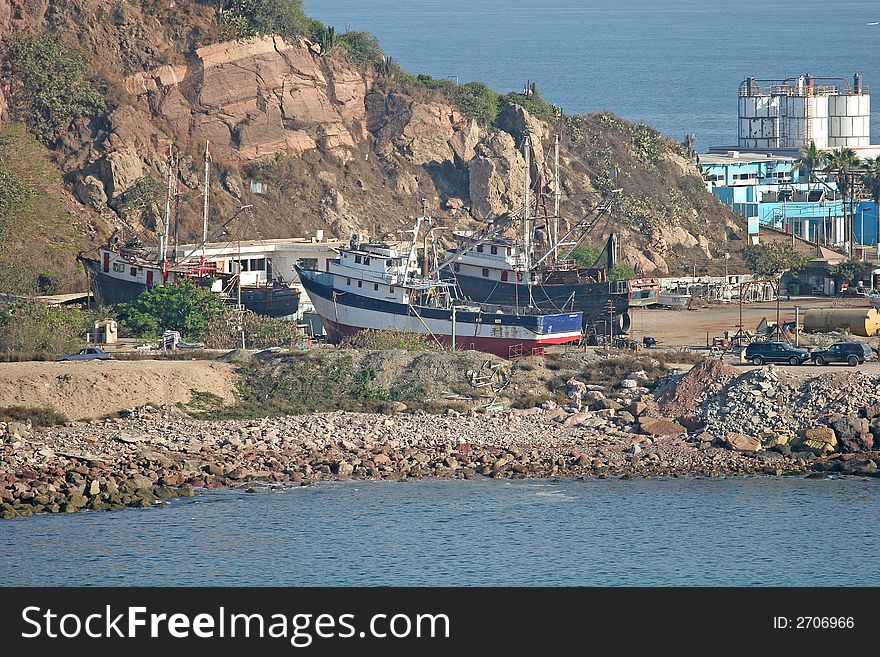 Old red white and blue fishing boat on shore