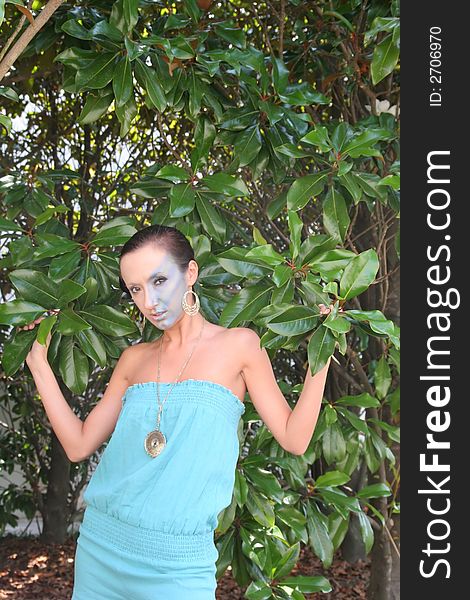 A fashion makeup model in blue dress and trees. A fashion makeup model in blue dress and trees