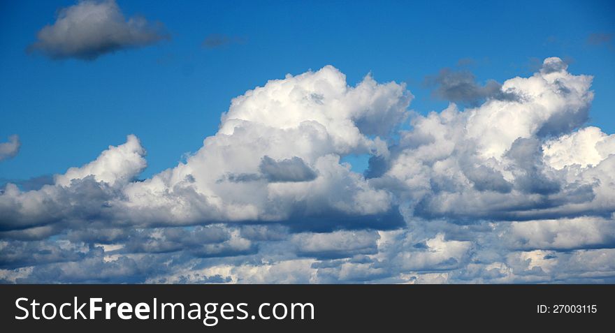 The pretty fluffy white cumulus clouds with some cumulonimbus drift across the blue Australian skies in spring with an occasional outpouring of precipitation which refreshes the new lush green growth of plants and grasses. The pretty fluffy white cumulus clouds with some cumulonimbus drift across the blue Australian skies in spring with an occasional outpouring of precipitation which refreshes the new lush green growth of plants and grasses.