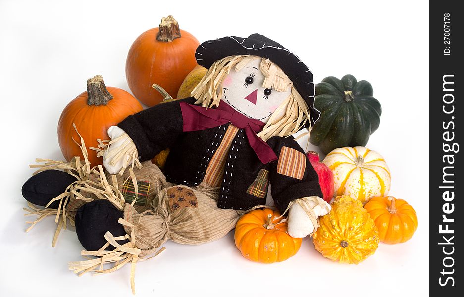 Harvest scarecrow laying on a bed squash, fairytale, cinderella, and Halloween pumpkins.