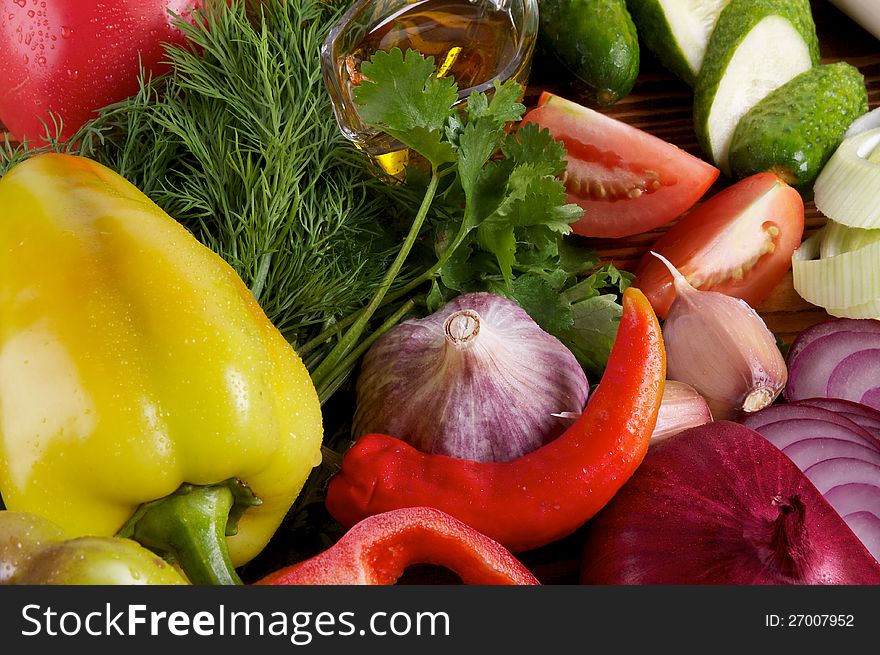 Yellow Bell Pepper and Various Vegetables with Greens, Garlic, Red Onion, Cucucmber and Tomatoes close up