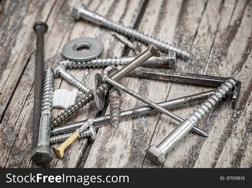 Metal nails and  screws  on wooden background