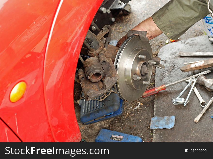 Mechanic fitting caliper on new disc brake. Mechanic fitting caliper on new disc brake.