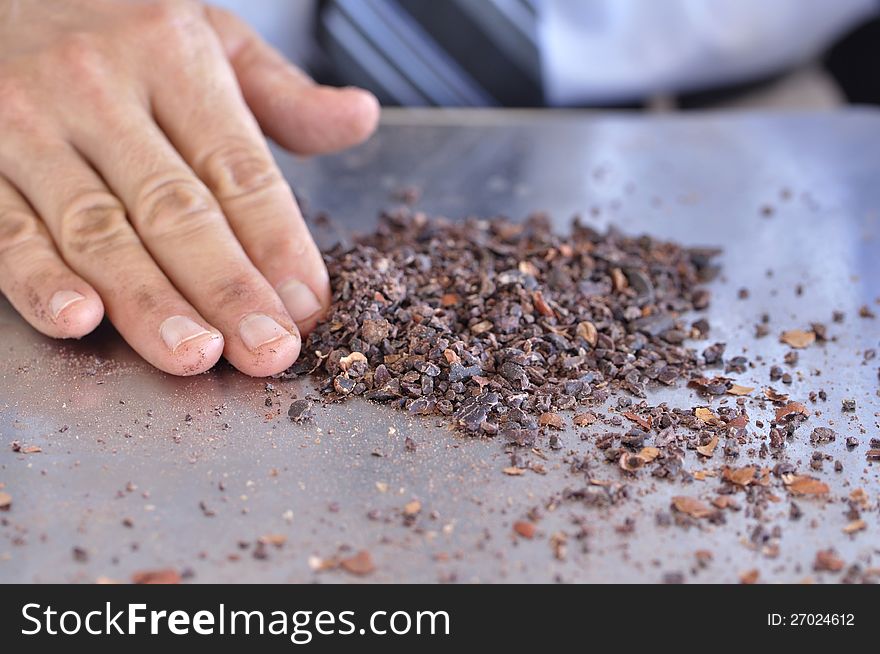 Closeup of homemade cocoa nibs collected on metal tray