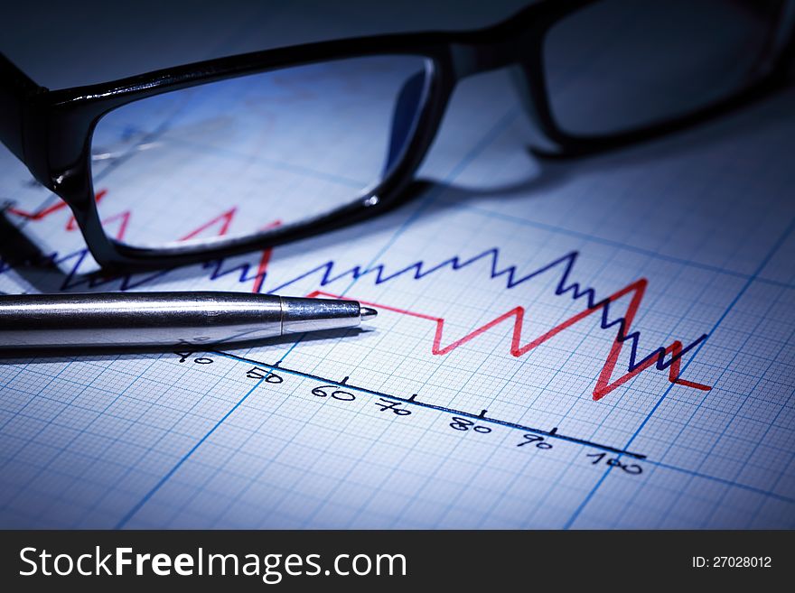 Business concept. Closeup of spectacles and pen on graph paper with diagram. Business concept. Closeup of spectacles and pen on graph paper with diagram