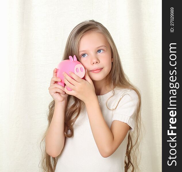 Little blong girl hearing how much money in piggy moneybox and dreaming about future purchase. Little blong girl hearing how much money in piggy moneybox and dreaming about future purchase